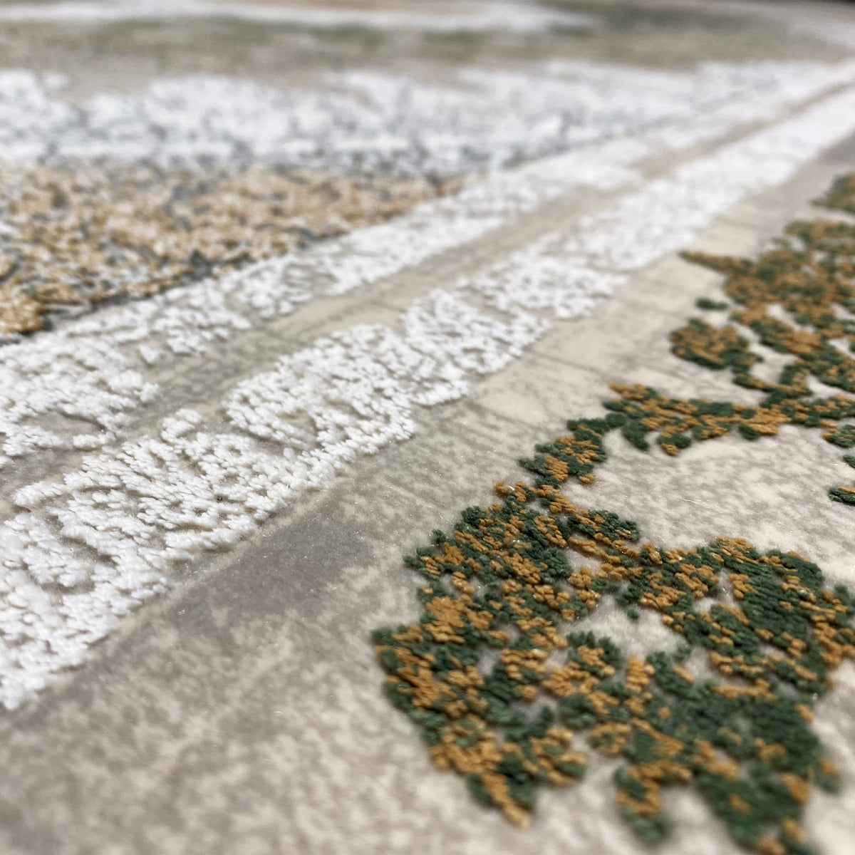 Rechteckiger Teppich mit silber-grauem Flor und gedämpften grünen Zierornamenten