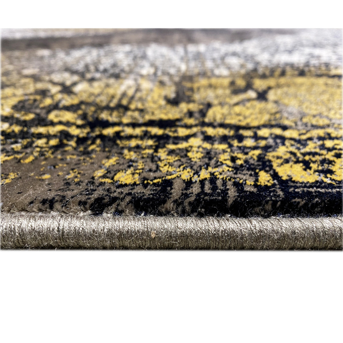 Teppichrand im Detail: schwarzer Flor mit silberner Kante und goldfarbenen Musterstreifen