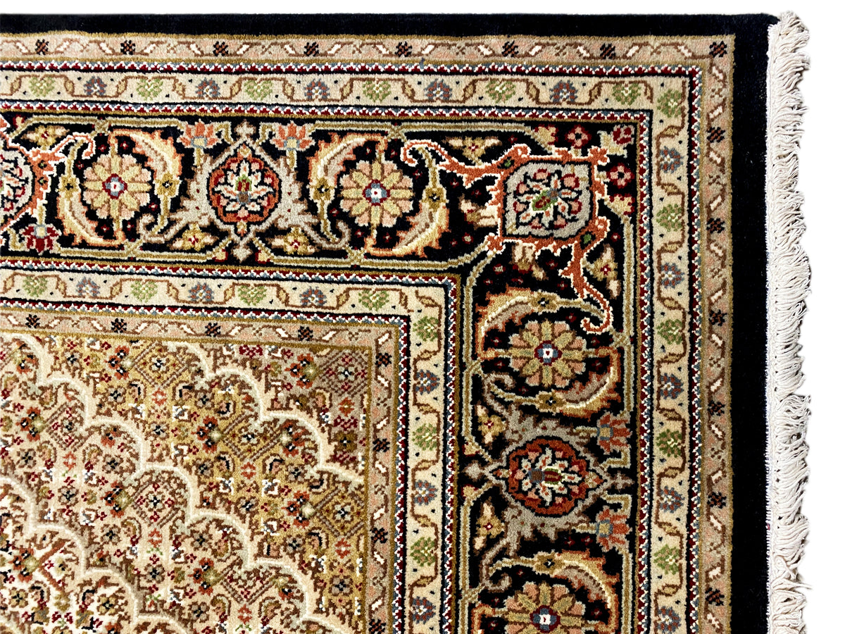 Nah an der Teppichkante: Fransen und detailreiche Ornamentbordüre in Beige und Dunkelbraun