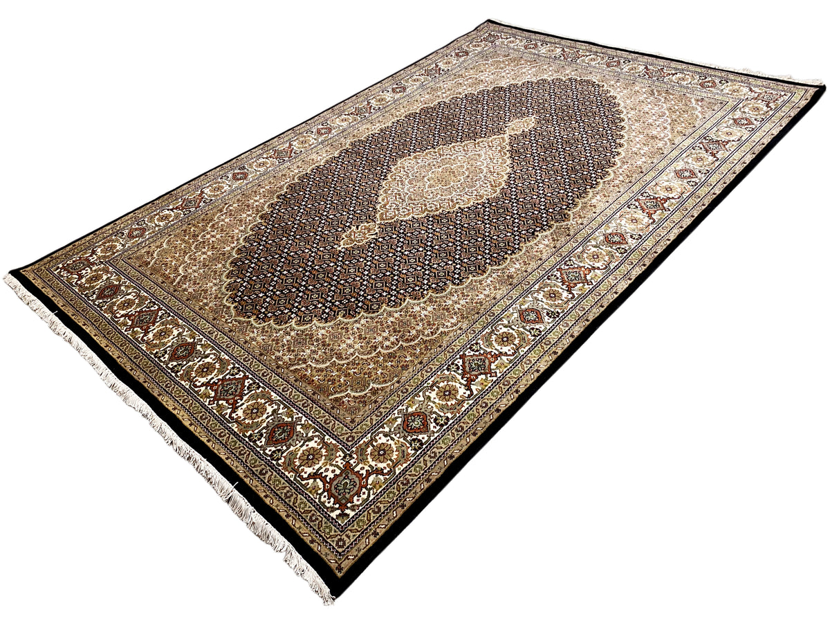 Teppich in Draufsicht mit dunkler Raute, beiger Umrahmung und ornamentalem Rand