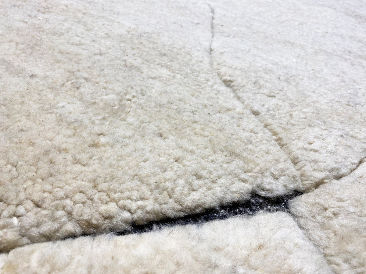 Nahaufnahme der Floroberfläche: cremefarbener Teppich mit blauem Rand