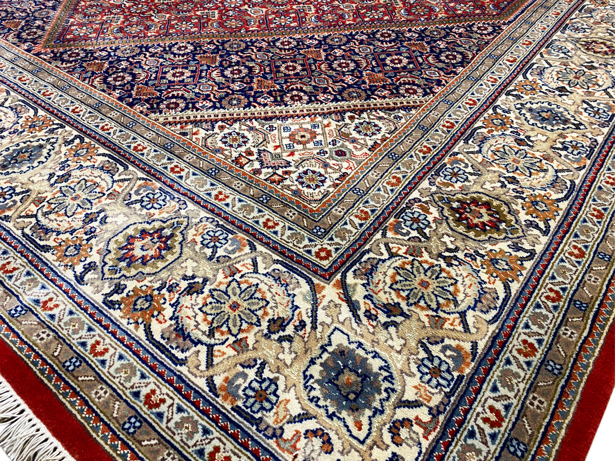 Detailansicht: blaues Zentrum mit floralen Motiven, umlaufende Ornamente und rote Akzente