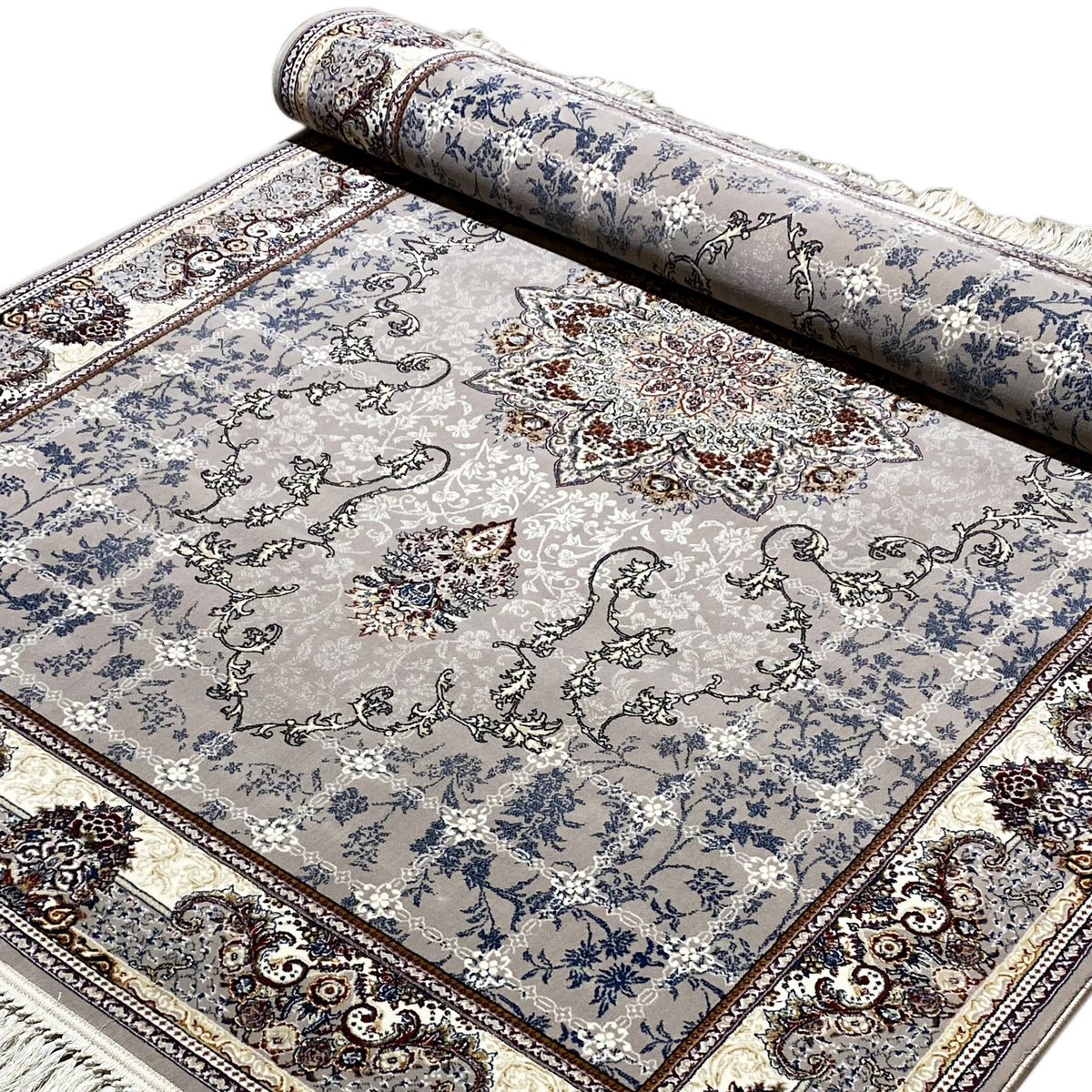 Nain-Teppich gerollt: blaues Ornamentdesign mit zentralen Motiven und Fransen am Rand
