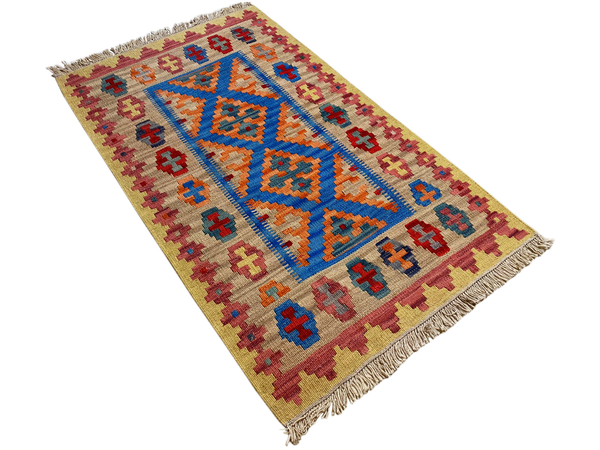 Beiger Kelim-Teppich mit blau-orangenem Mittelmotiv und farbigen Randornamenten, Fransen
