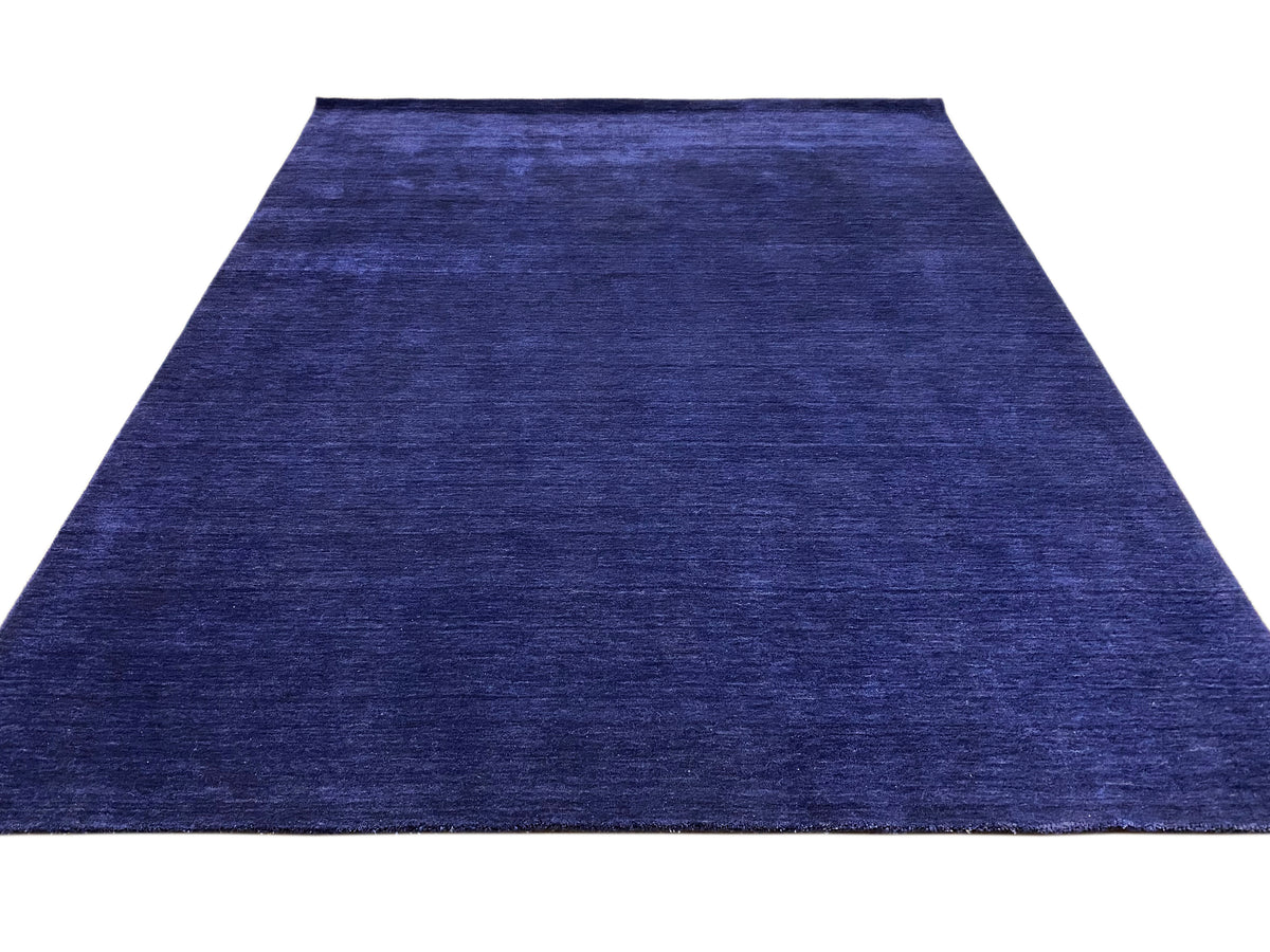 Blauer Teppich mit schmalem Rapport und gleichmäßiger Kurzflor-Struktur.
