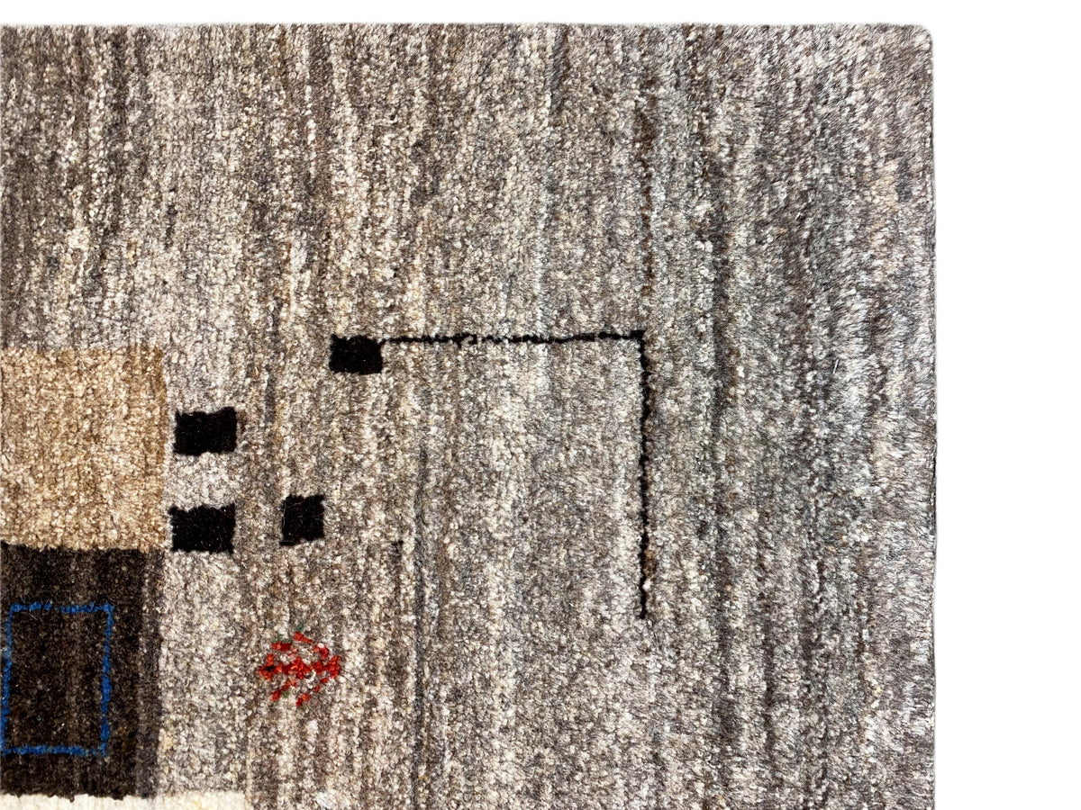 Nahaufnahme vom Flor eines Gabbeh Teppichs in hellem Beige-Grau mit Linienmuster