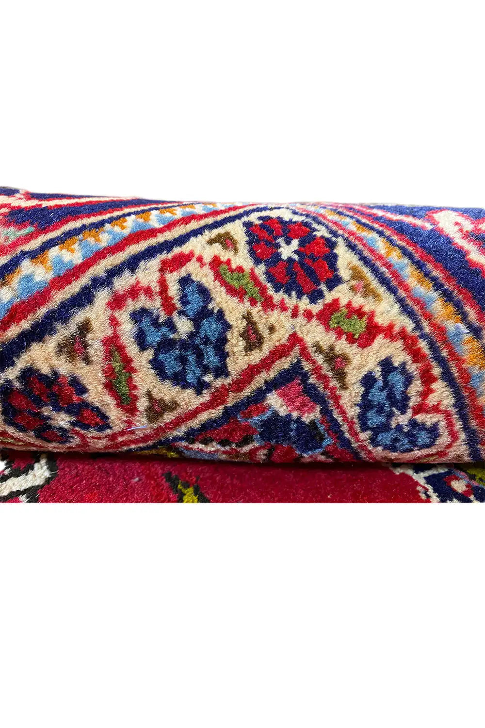 Teppich-Detail: bunte Ornamentbordüre auf rotem Grund, sichtbarer Flor