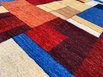 Gabbeh-Luri-Teppich Nahaufnahme: kräftige Farbkacheln in Rot, Blau, Dunkelbraun und Beige.