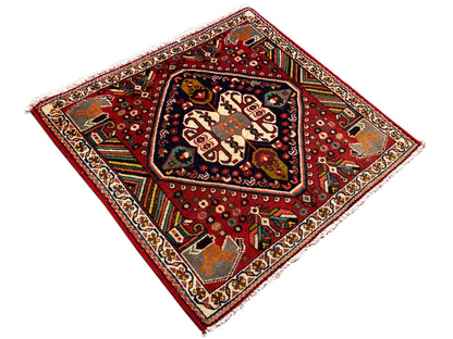 Orientalischer Teppich im Quadratformat mit rotem Grund und blau umrandetem Mittelfeld