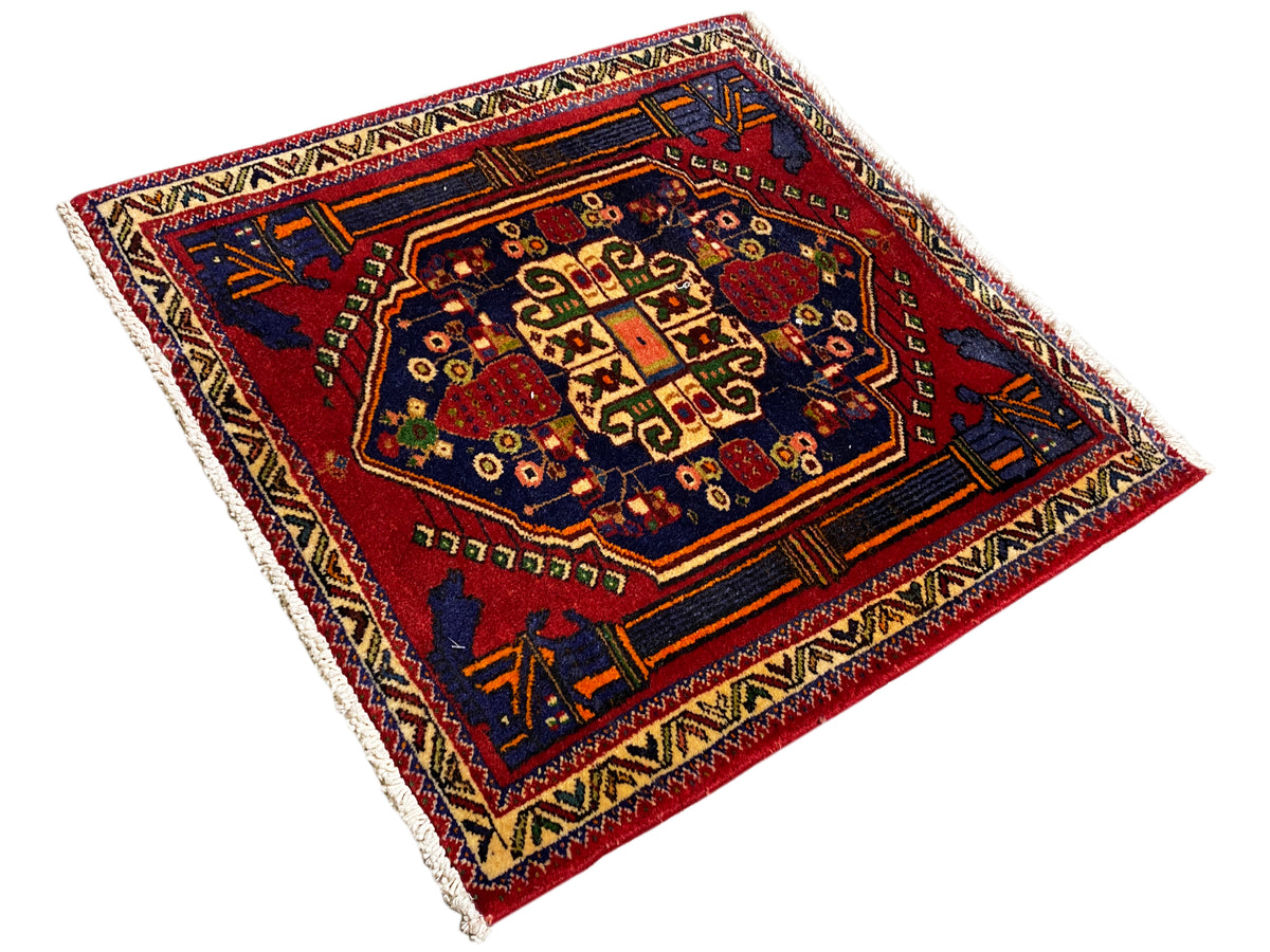 Poshti-Teppich 66x62 cm diagonal: blau-rote Bordüre mit zahlreichen Ornamenten.
