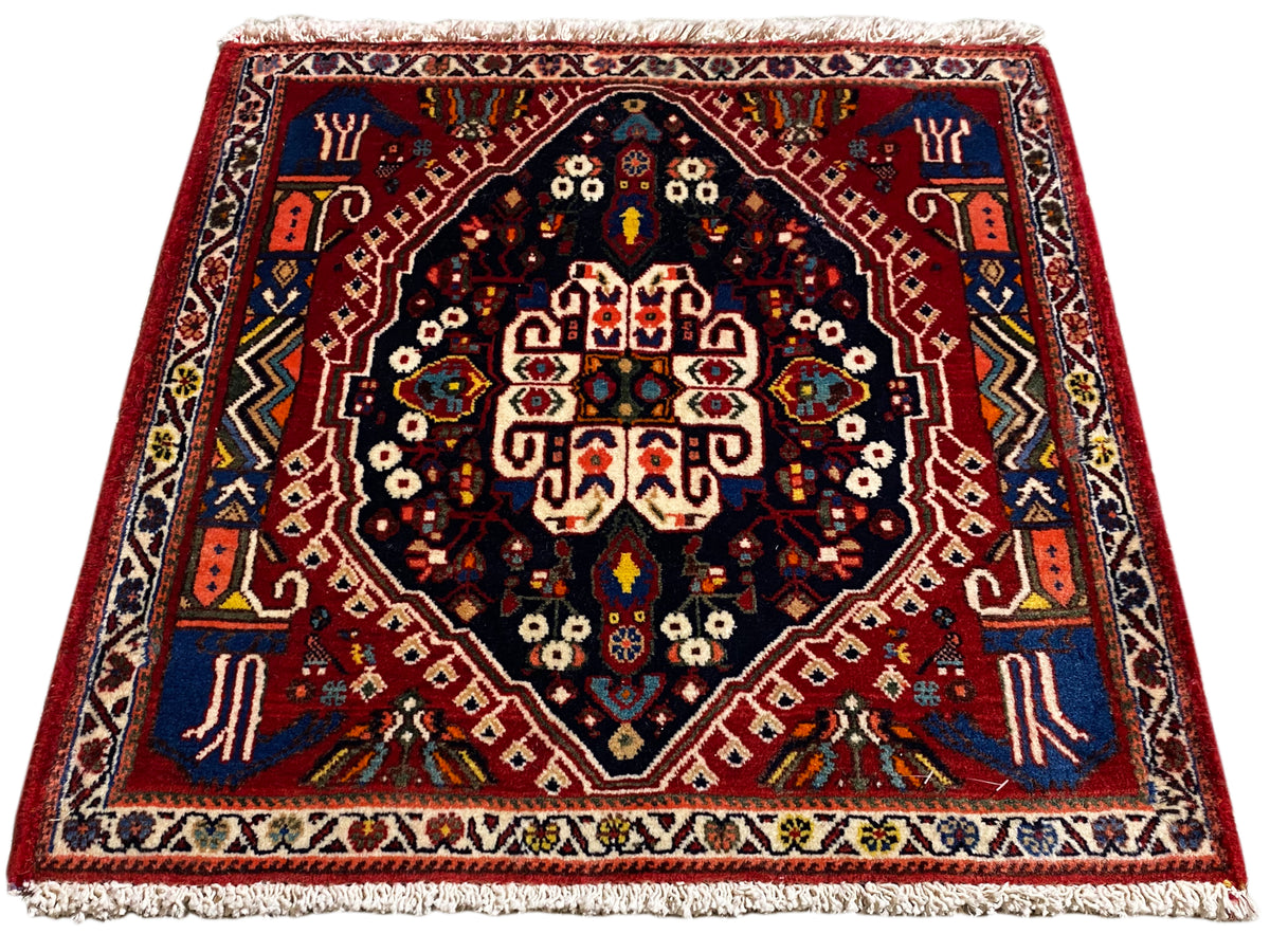 Teppich mit rotem Rand, dunkelblauem Zentrum und mehrfarbigen Ornamente, Fransen